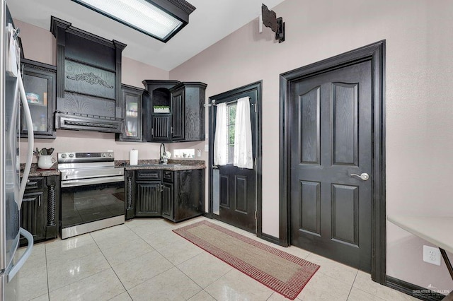 3908 Hill Crest Dr, Mission, TX 78573 - kitchen featuring appliances with stainless steel finishes, exhaust hood, dark cabinetry, vaulted ceiling, and light tile patterned floors