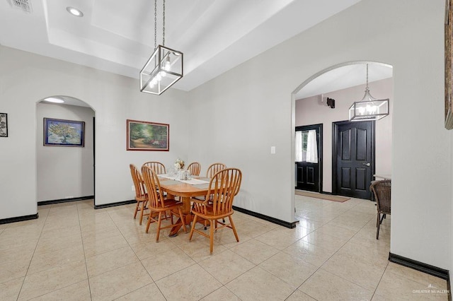 3908 Hill Crest Dr, Mission, TX 78573 - dining space with arched walkways, light tile patterned floors, a chandelier, a tray ceiling, and recessed lighting