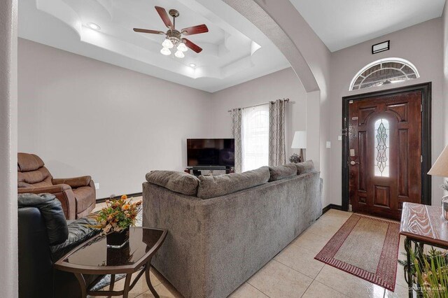 3908 Hill Crest Dr, Mission, TX 78573 - living room featuring ceiling fan, arched walkways, light tile patterned flooring, and a tray ceiling