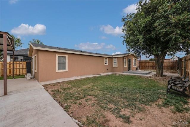721 W 4th St, Mission, TX 78572 - back of property featuring a yard, a patio area, stucco siding, and a fenced backyard