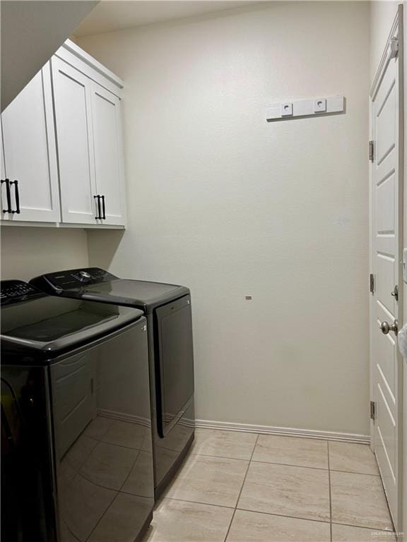 laundry area with cabinets, light tile patterned flooring, and washer and dryer