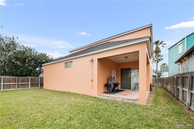 back of property with a lawn and a patio area