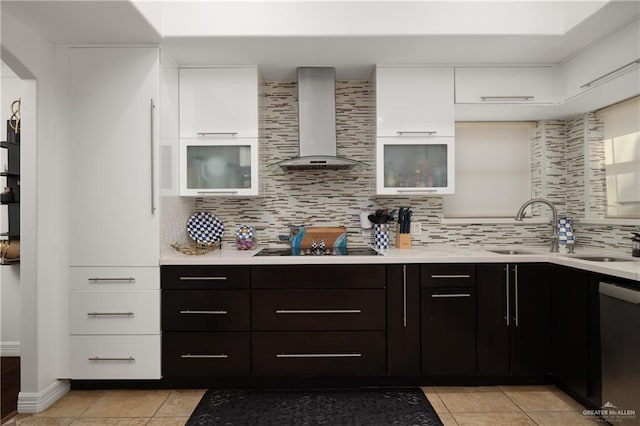 kitchen with dishwasher, white cabinets, wall chimney range hood, sink, and light tile patterned floors