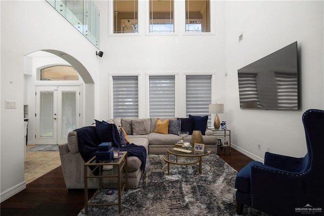 living room featuring french doors, dark hardwood / wood-style flooring, and a high ceiling