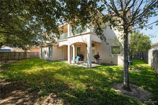 back of house featuring a yard and a patio area