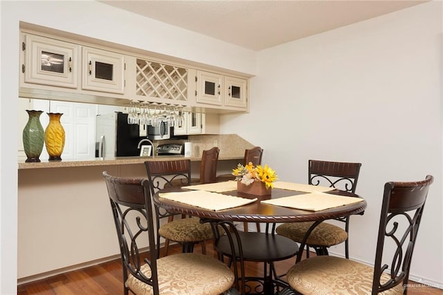 dining space with indoor bar and dark hardwood / wood-style flooring