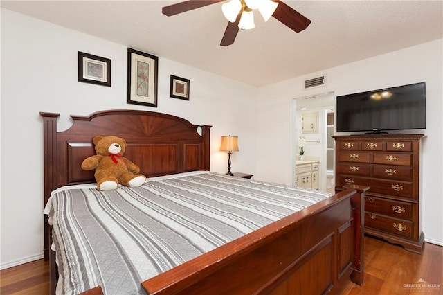 bedroom featuring ceiling fan, dark hardwood / wood-style flooring, and ensuite bath