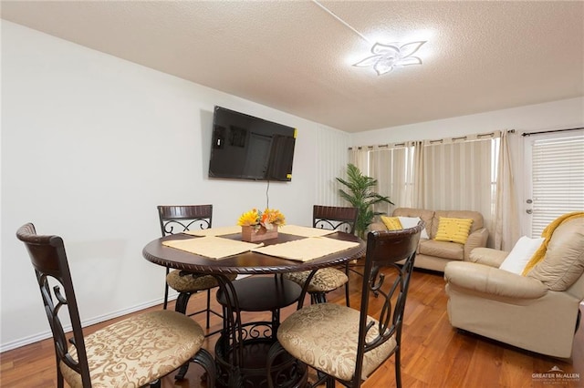 dining area featuring hardwood / wood-style floors and a textured ceiling