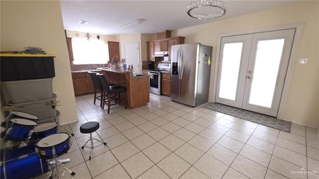 2216 N 48th St, Mcallen, TX 78501 - kitchen with a breakfast bar area, french doors, a center island, under cabinet range hood, and stainless steel appliances