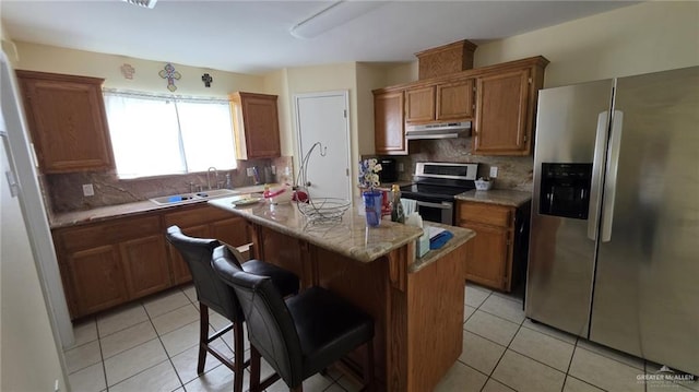 2216 N 48th St, Mcallen, TX 78501 - kitchen with light tile patterned flooring, a center island, under cabinet range hood, a sink, and stainless steel appliances