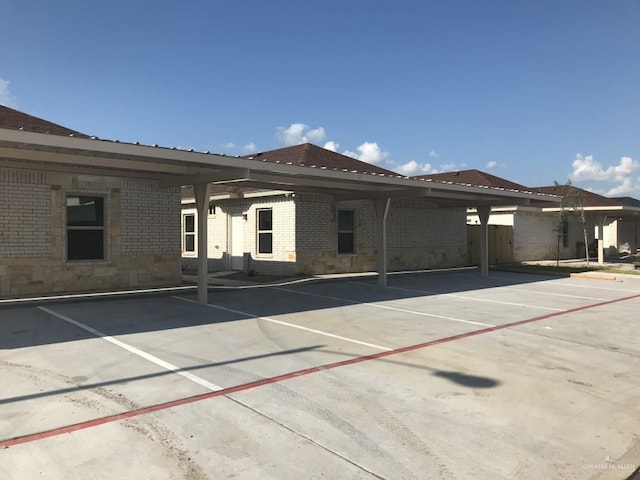 back of house with brick siding and covered parking