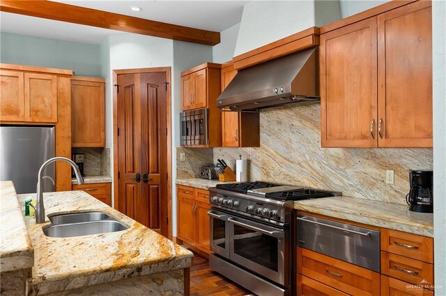 4616 Gulf Blvd S, Unit South, South Padre Island, TX 78597 - kitchen featuring stainless steel appliances, a sink, a warming drawer, wall chimney exhaust hood, and brown cabinetry