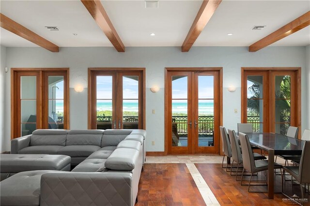4616 Gulf Blvd S, Unit South, South Padre Island, TX 78597 - living room with french doors, beamed ceiling, plenty of natural light, baseboards, and wood finished floors