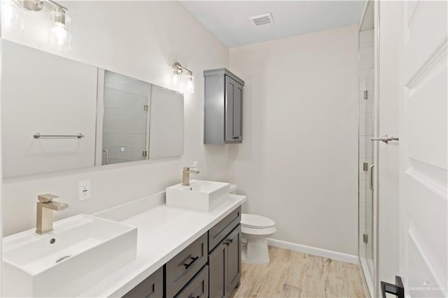 bathroom featuring a shower stall, toilet, visible vents, and a sink