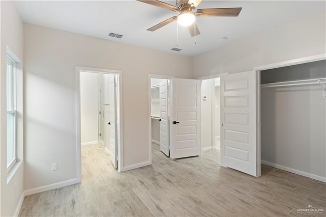 unfurnished bedroom featuring light wood-style floors, visible vents, and a closet