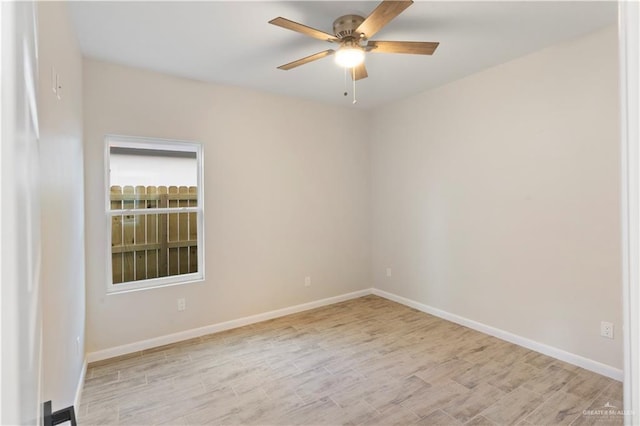 spare room with baseboards, a ceiling fan, and wood finished floors