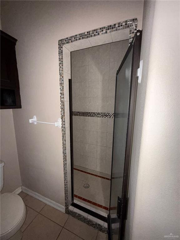 bathroom featuring toilet, tile patterned flooring, and a shower with door