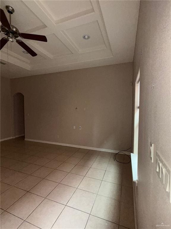 spare room with ceiling fan, light tile patterned floors, beam ceiling, and coffered ceiling