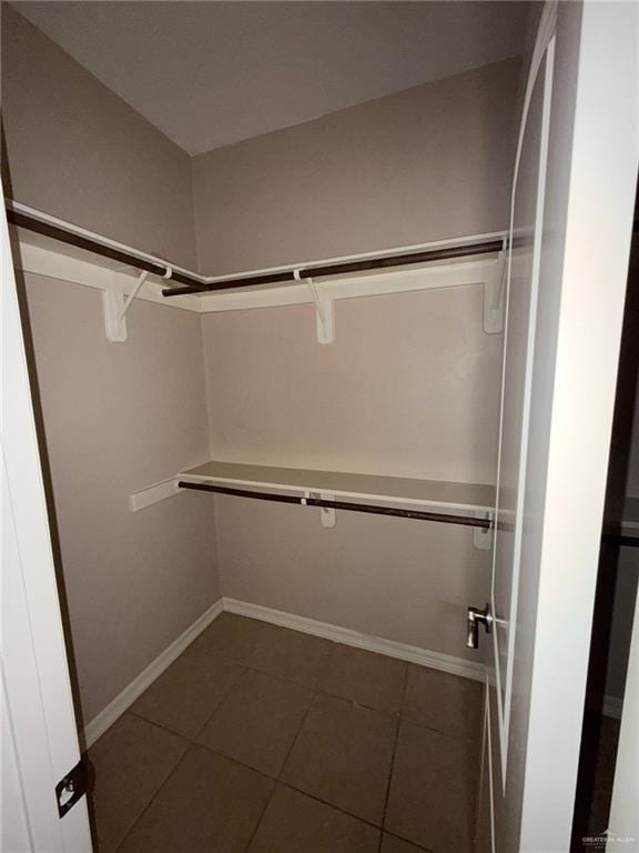 spacious closet with dark tile patterned floors