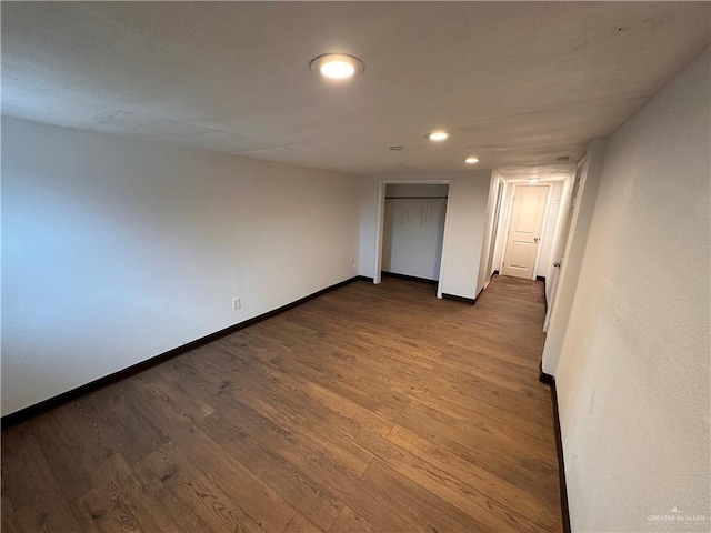 empty room with dark wood-style floors, recessed lighting, and baseboards