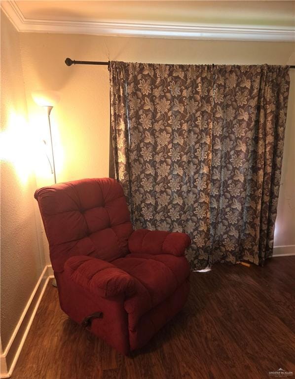 living area with baseboards, ornamental molding, and wood finished floors