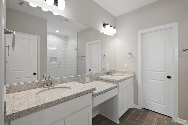 full bathroom featuring a sink, a stall shower, double vanity, and visible vents