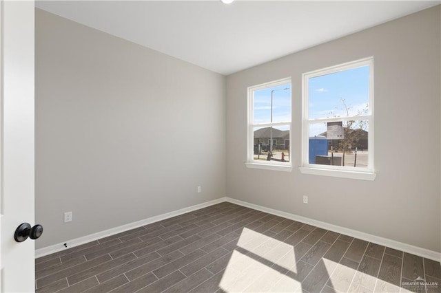 spare room featuring baseboards and wood tiled floor