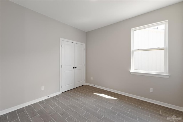 spare room featuring baseboards and wood tiled floor