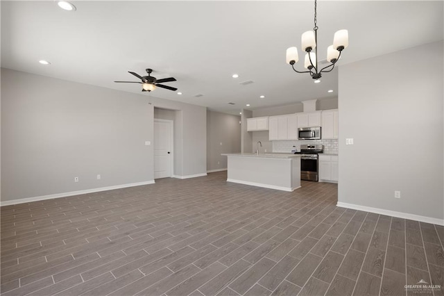 kitchen with backsplash, recessed lighting, open floor plan, and appliances with stainless steel finishes