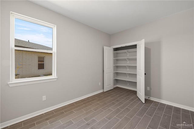 unfurnished bedroom featuring baseboards and dark wood-style floors