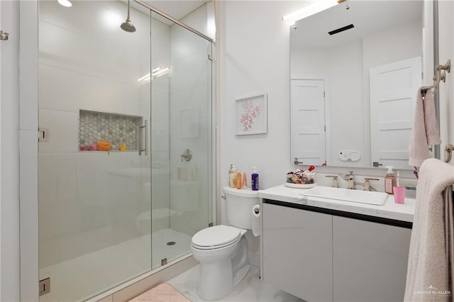 bathroom with vanity, toilet, and a shower with shower door