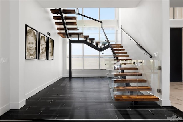 stairs with plenty of natural light and hardwood / wood-style flooring