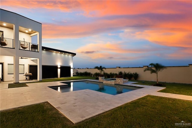 pool at dusk featuring an in ground hot tub, a yard, a water view, and a patio