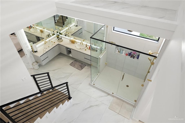 interior space with a skylight, a shower with door, and sink