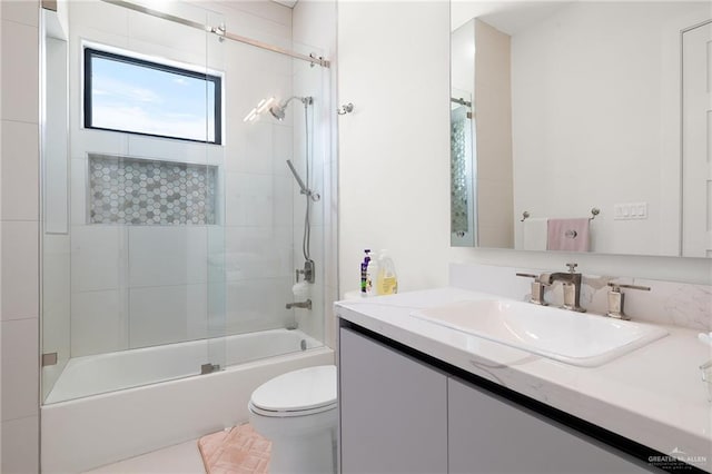 full bathroom featuring toilet, combined bath / shower with glass door, and vanity