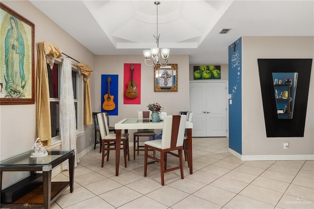 dining room featuring a tray ceiling, an inviting chandelier, and light tile patterned flooring