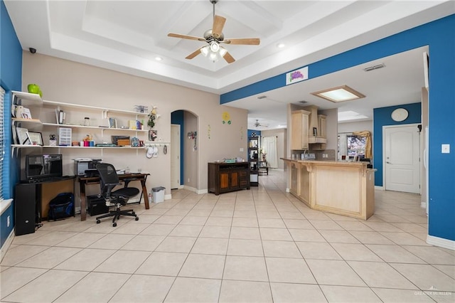 office area featuring ceiling fan, light tile patterned flooring, and a raised ceiling