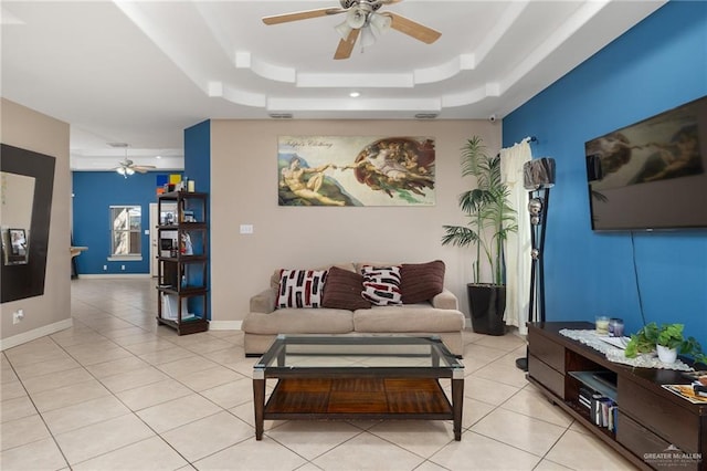 tiled living room featuring a tray ceiling and ceiling fan