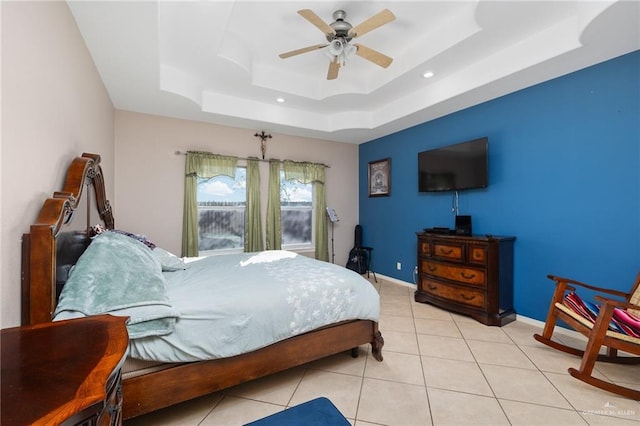 tiled bedroom featuring a raised ceiling and ceiling fan