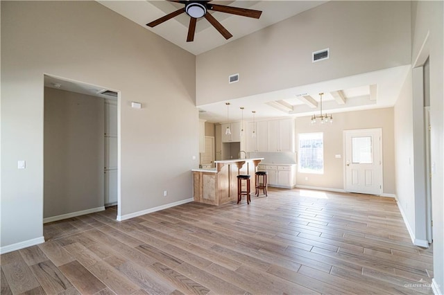 6608 Primavera St, Pharr, TX 78577 - living area featuring a ceiling fan, a chandelier, light wood-style flooring, a towering ceiling, and baseboards