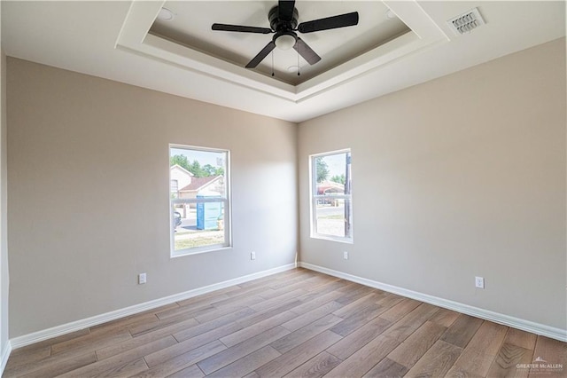 6608 Primavera St, Pharr, TX 78577 - empty room with a raised ceiling, light wood finished floors, ceiling fan, and baseboards