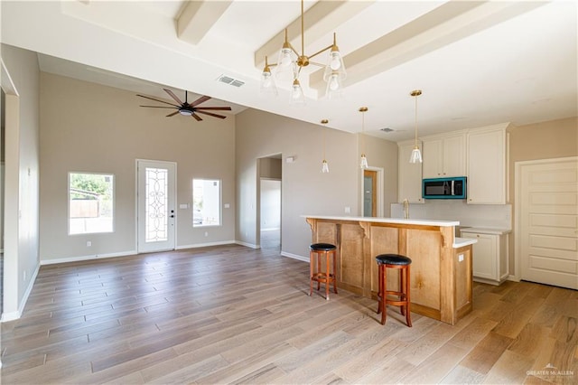 6608 Primavera St, Pharr, TX 78577 - kitchen with a chandelier, light wood-style flooring, a kitchen island with sink, light countertops, and a kitchen bar