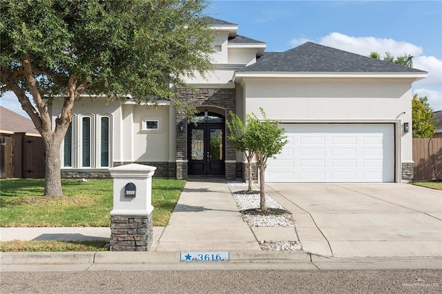 view of front of property featuring a garage, a front yard, and french doors