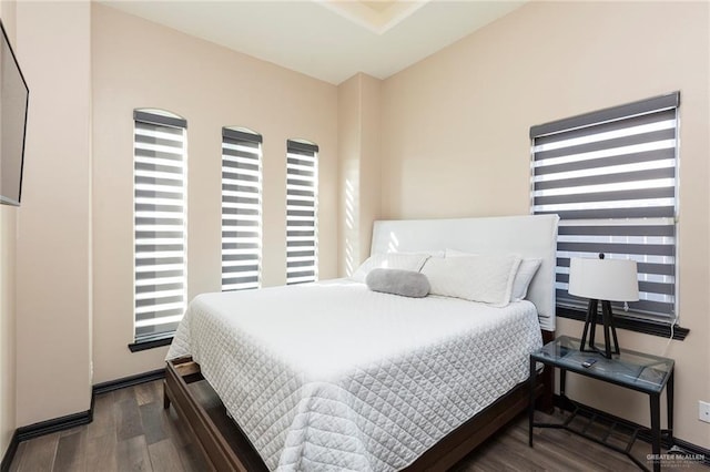 bedroom with dark hardwood / wood-style flooring