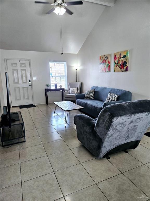 living room featuring beam ceiling, ceiling fan, light tile patterned floors, and high vaulted ceiling