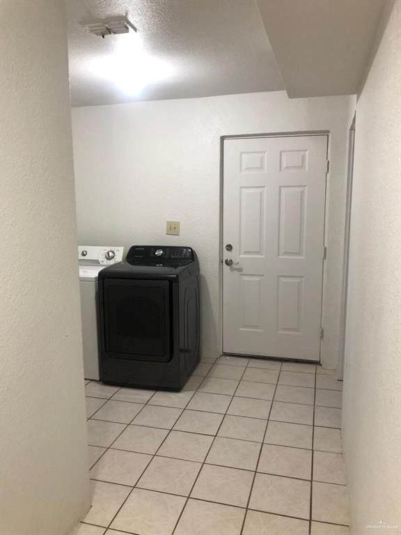 laundry room with light tile patterned floors and washing machine and clothes dryer