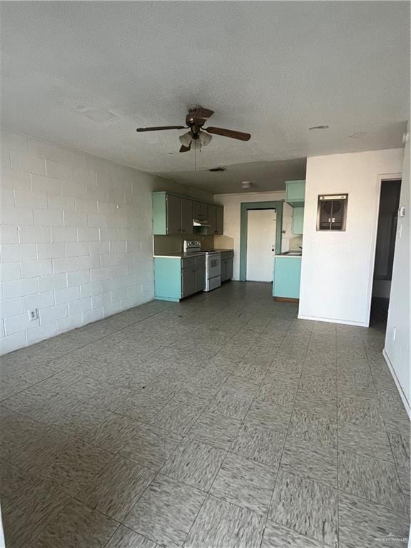 unfurnished living room with ceiling fan and a textured ceiling