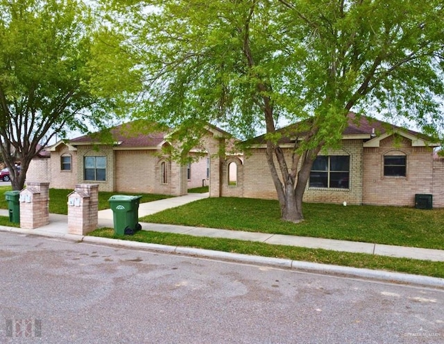 single story home featuring a front lawn