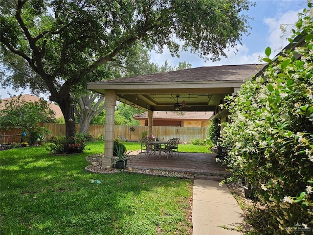 view of yard featuring a patio, ceiling fan, and a fenced backyard