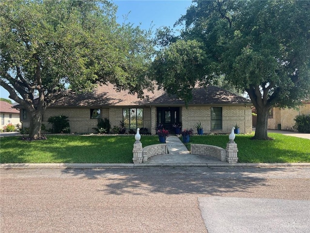 single story home with a front lawn and brick siding